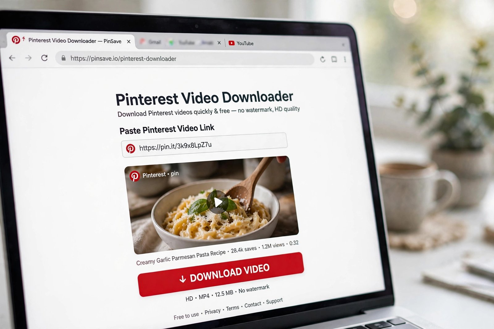 Laptop screen showing an online Pinterest video downloader with a pasted link and a red download button