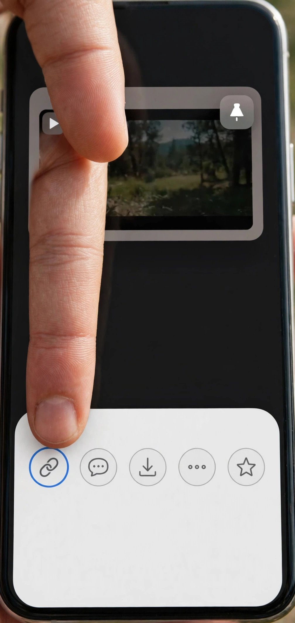 Finger tapping the copy link icon in a phone share menu over a video pin