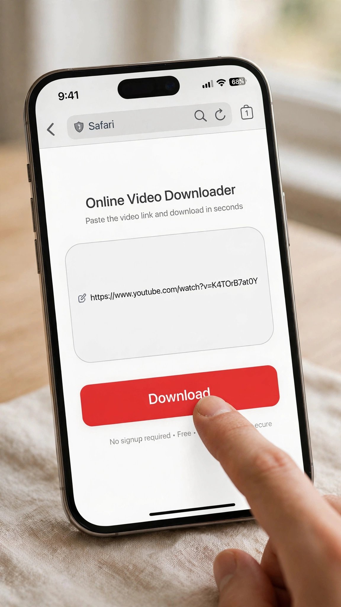 An iPhone in Safari showing a simple 'Online Video Downloader' webpage, with a video link pasted into the rounded URL input field and a finger tapping the prominent red Download button below.